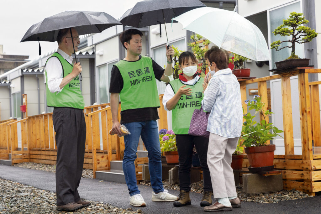 仮設住宅「宅田町第１団地」を訪問した杉本満さん、新留風太さん、佐渡麗子さん（左から）。新留さんは石川民医連事務局支援として全日本民医連から出向してい